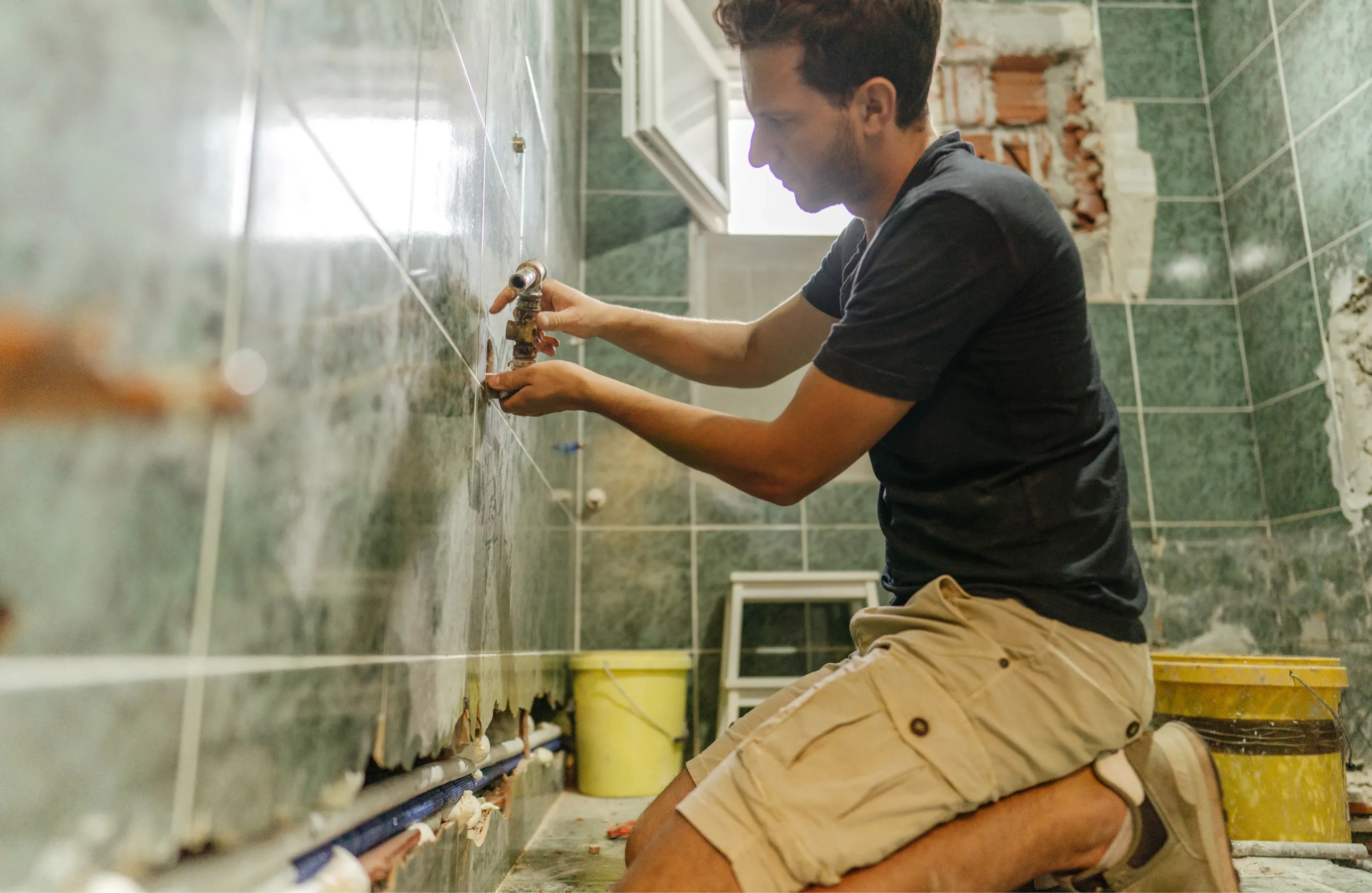 Professional bathroom renovation in Melbourne showing plumbing installation, tile removal, and waterproofing work by licensed tradespeople